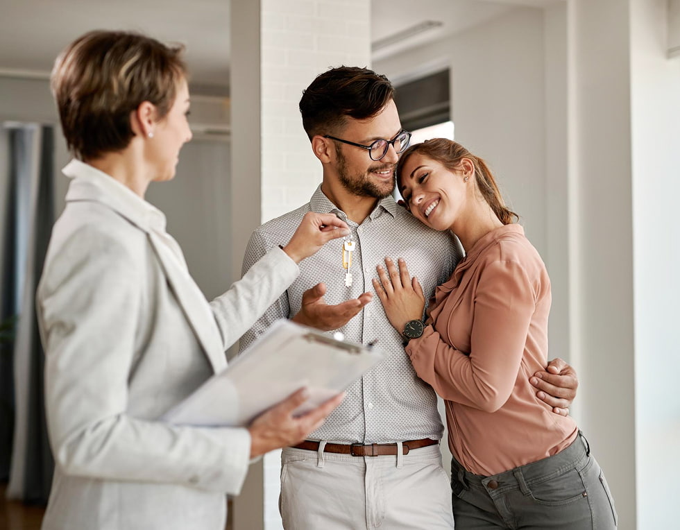Immobilienmakler übergibt Wohnungsschlüssel An Paar